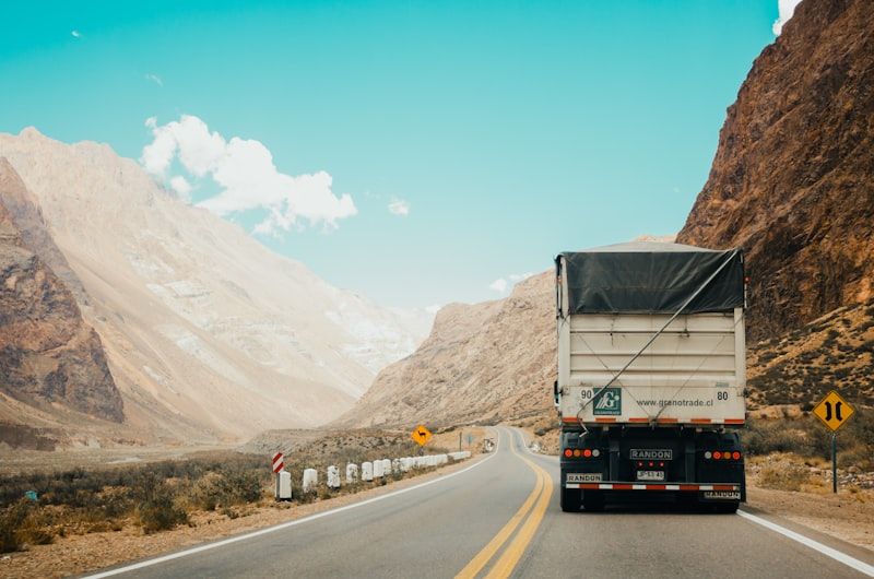 A semi-truck on a highway through mountain country